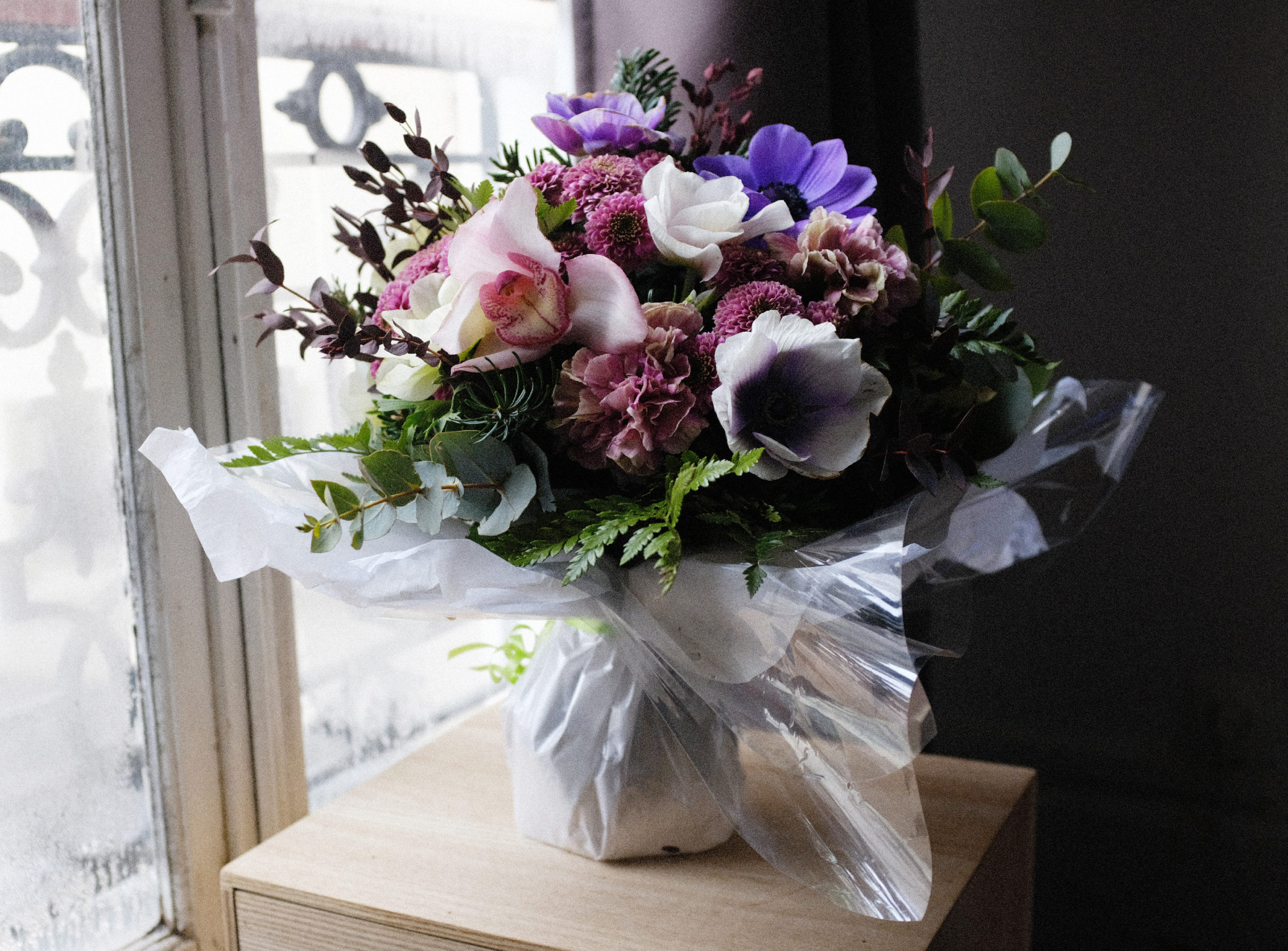 Bouquet rond (emballage bouquet bulle). Anémones, orchidées, chrysanthèmes, œillets, sapin, eucalyptus, fougère