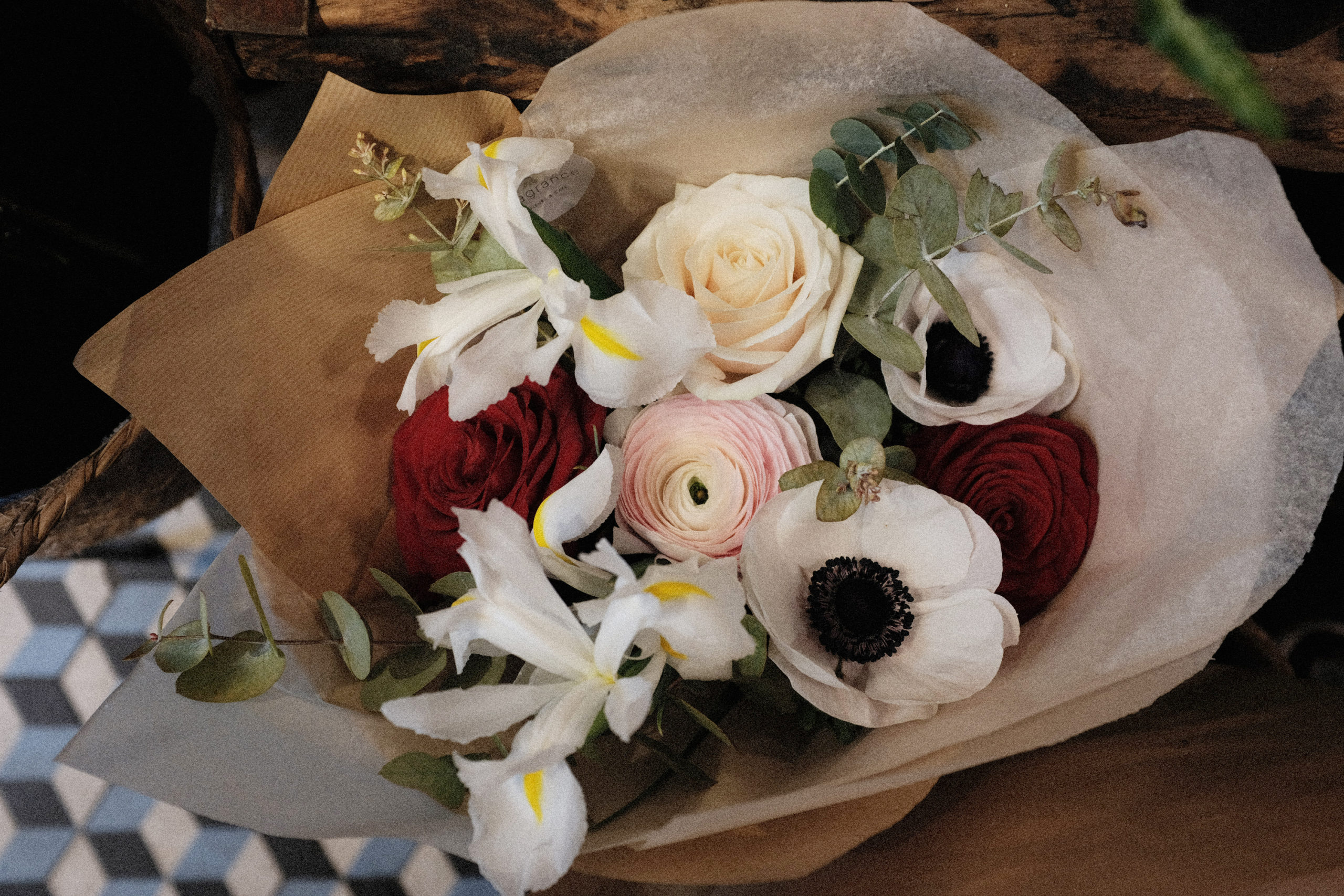 Composition de fleurs fraîches et emballage kraft (eucalyptus, iris, renoncule Hanoï, roses Red Naomi, anémones mistral, rose Dorchester), valeur 35€