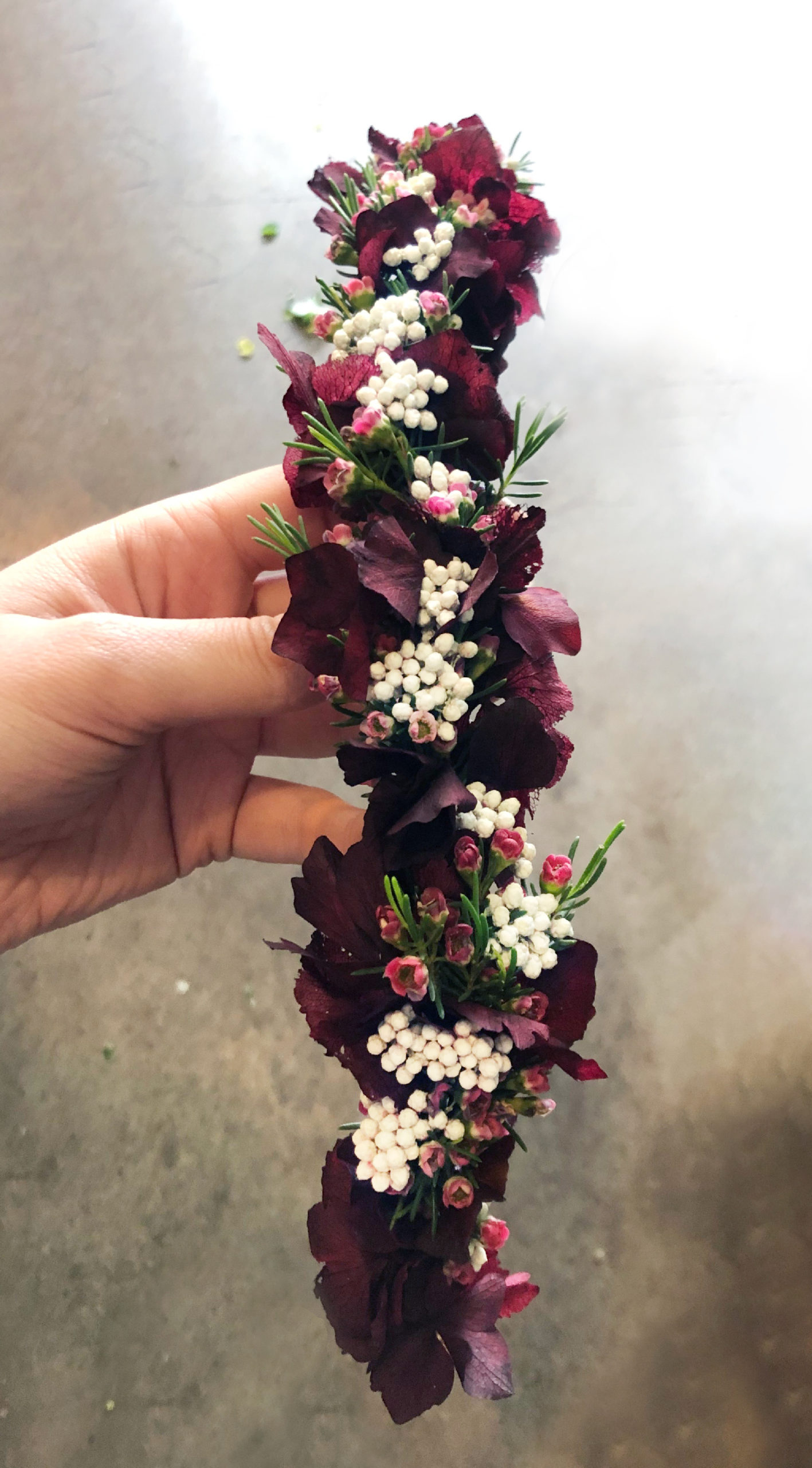 Couronne de fleurs fraîches et séchées (riz, wax flower et hortensia teinté) sur structure en fil de fer.